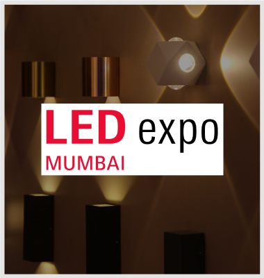 A row of various wall-mounted LED lights with geometric designs is displayed in a dim setting.