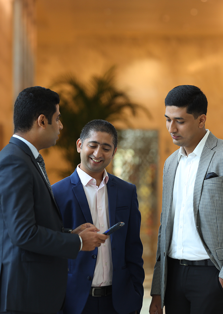 Three people discussing with each other in jio world centre's lobby